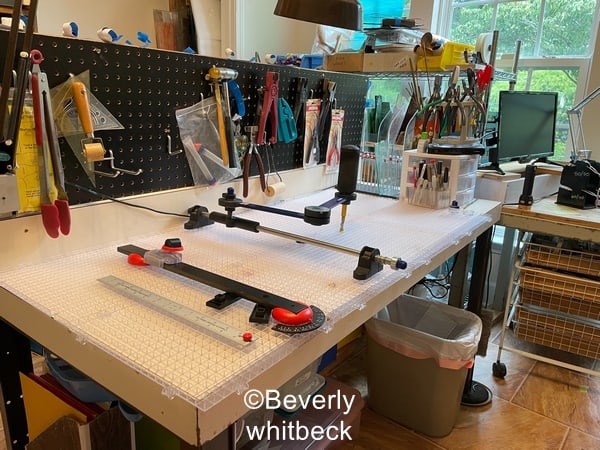 A studio set up for making stained glass for a wheelchair user showing the cutters mate and beetle bits systems