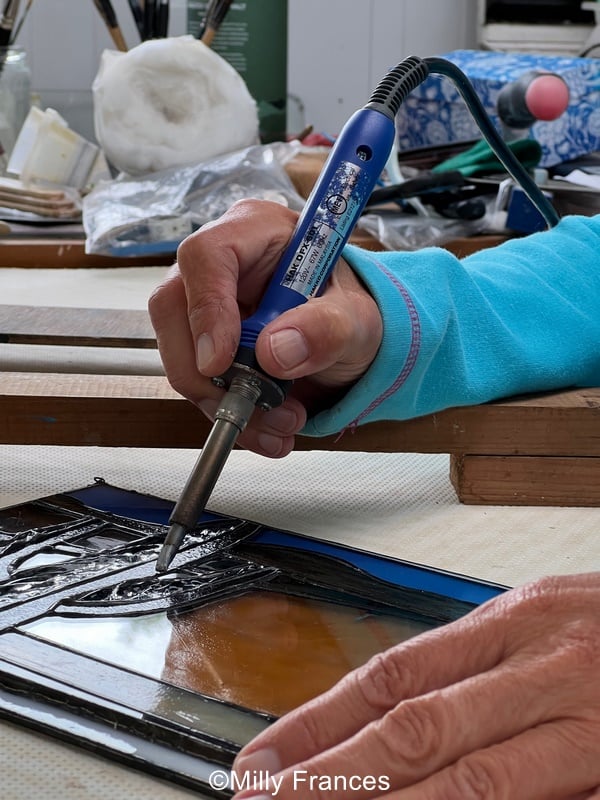 resting your arm on a rest when soldering stained glass might reduce shaking