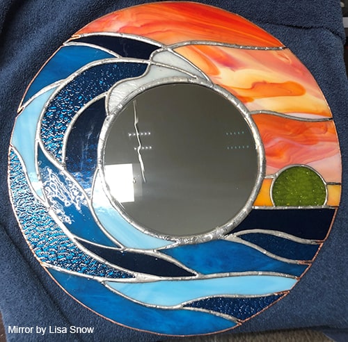 A stained glass mirror with a wave on it.